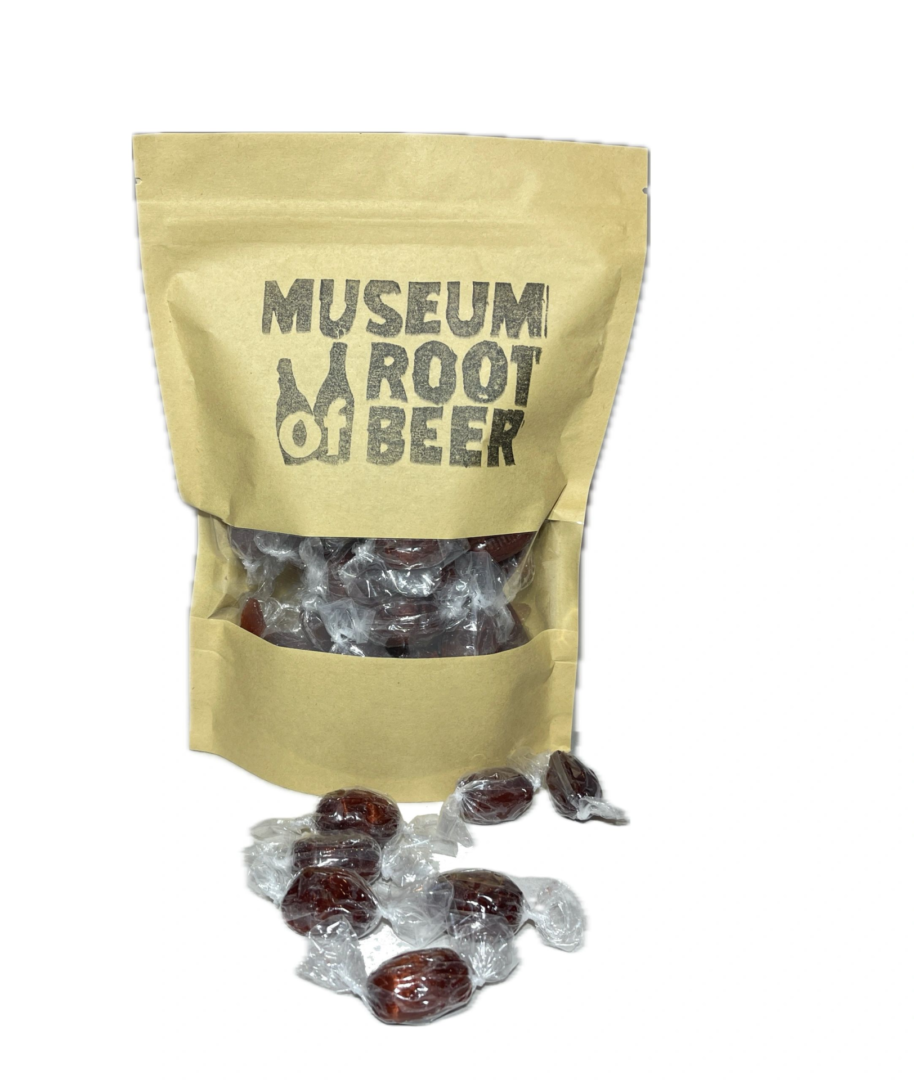 A brown paper bag labeled "Root Beer Barrel Hard Candy" contains individually wrapped candies, evoking the nostalgic feel of treasures from a beer museum. Some candies are scattered outside the bag.